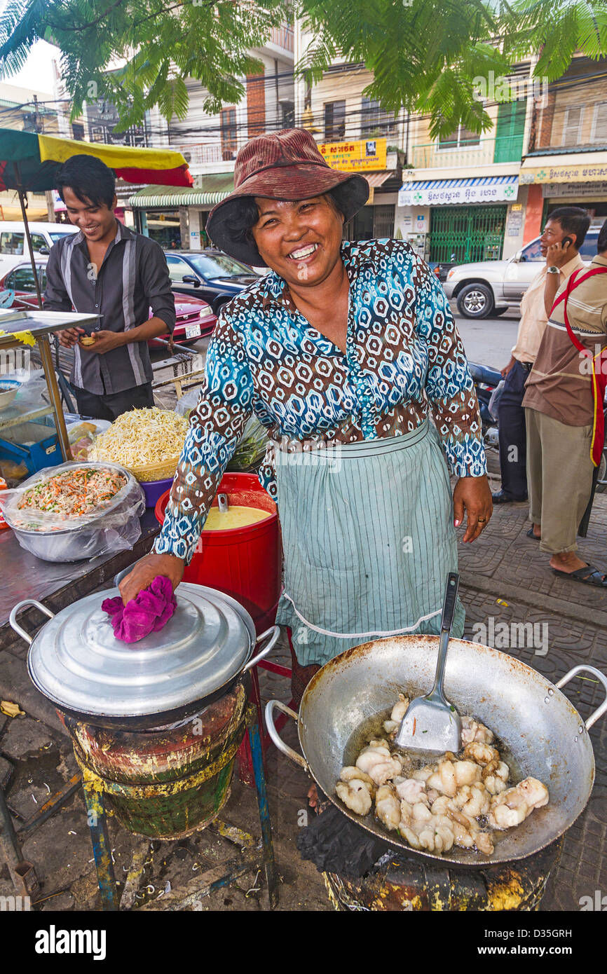 Femme sur le porc et les crevettes cuisiniers de rue à vendre à Phnom Penh, Cambodge. Banque D'Images
