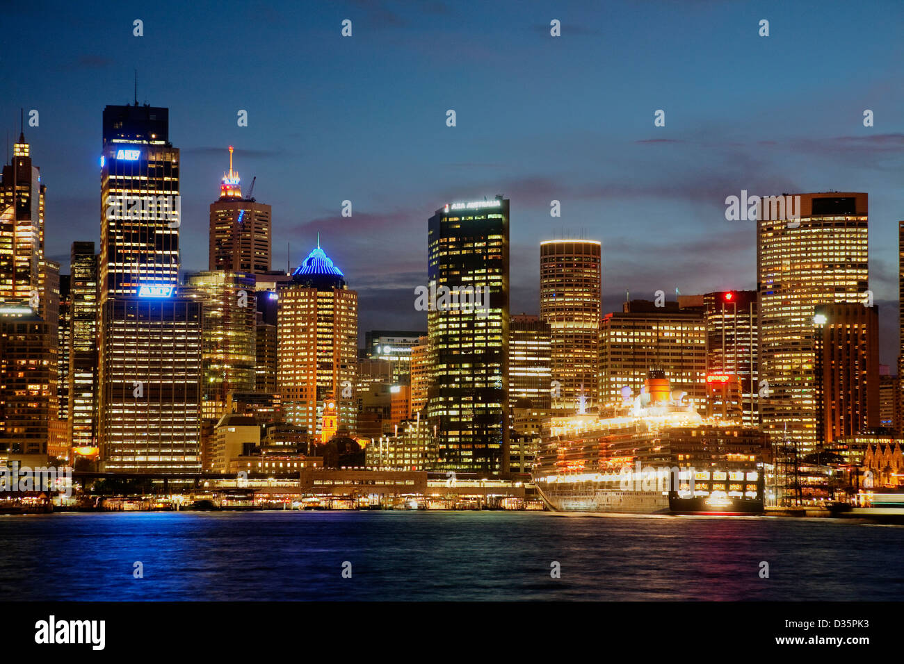 Bateau de croisière Queen Elizabeth Curnards accosté au terminal passagers d'outre-mer avec Sydney CBD skyline at sunset. Banque D'Images