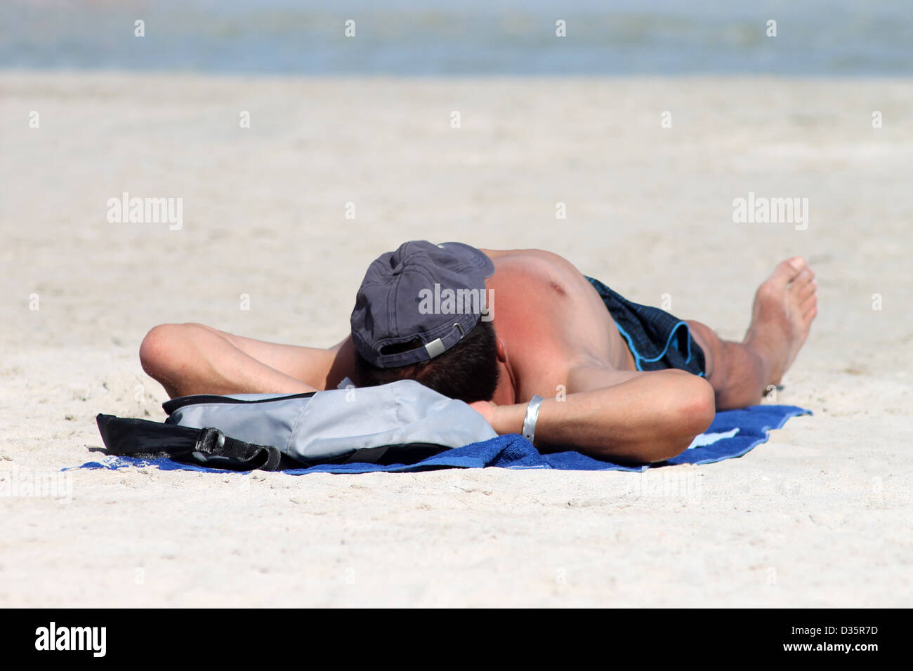 Homme se faire bronzer sur la plage Banque de photographies et d’images