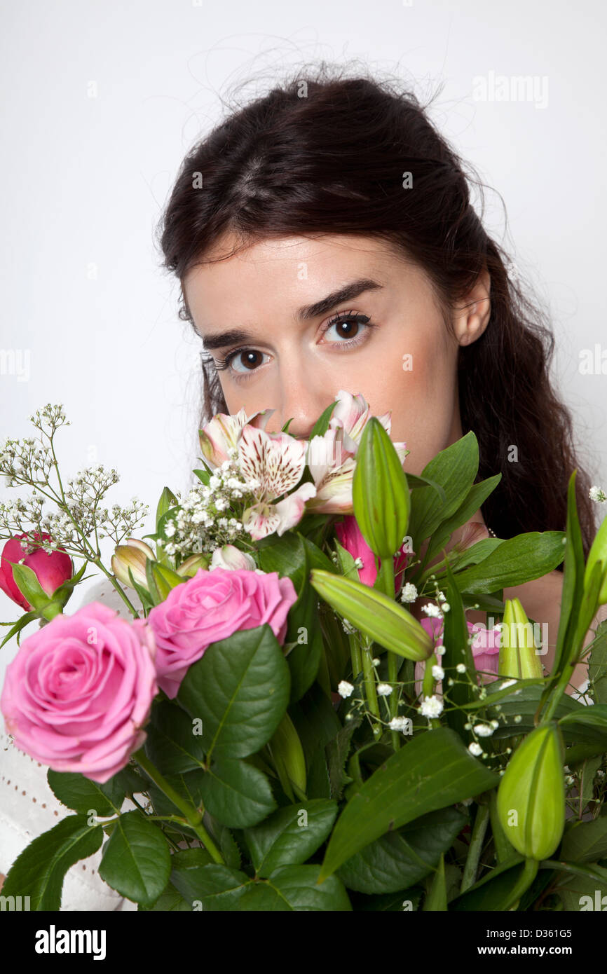 Les yeux de femme au-dessus de bouquet de fleurs Banque D'Images
