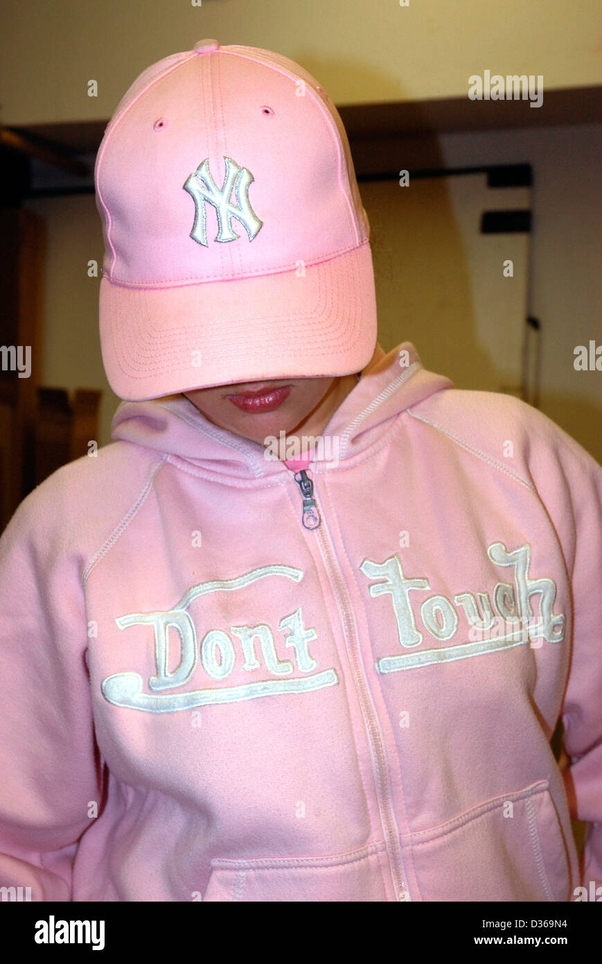 Une jeune fille portant une veste avec fermeture éclair rose les mots  'Don't Touch' écrit sur la poitrine, et une casquette rose Photo Stock -  Alamy
