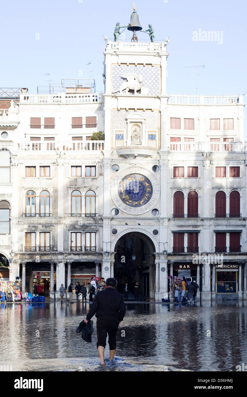 Homme marchant dans les inondations de la Place Saint Marc Venise Italie Piazza San Marco Banque D'Images