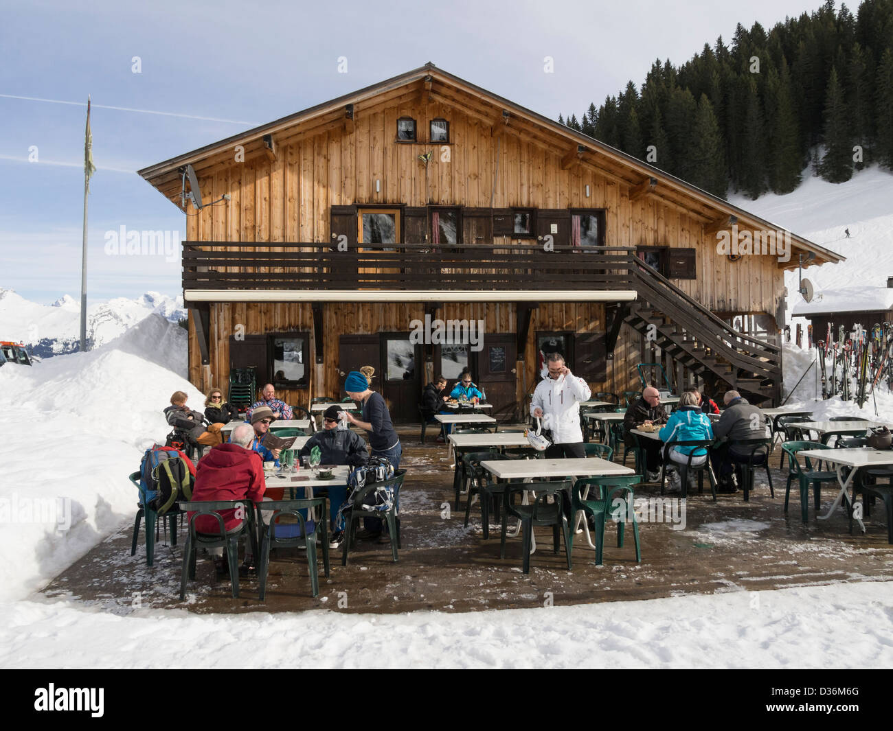 Les gens à l'extérieur salle à manger Gîte du Lac de Gers au bord du lac restaurant alpin ski dans le Grand Massif dans les Alpes. Sixt Samoëns France Banque D'Images