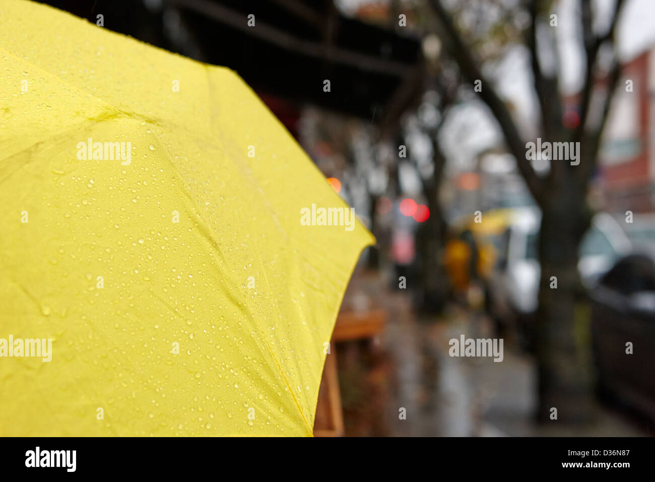 La pluie tomber d'un parapluie jaune sur un jour de pluie, au centre-ville de Vancouver, BC Canada Banque D'Images