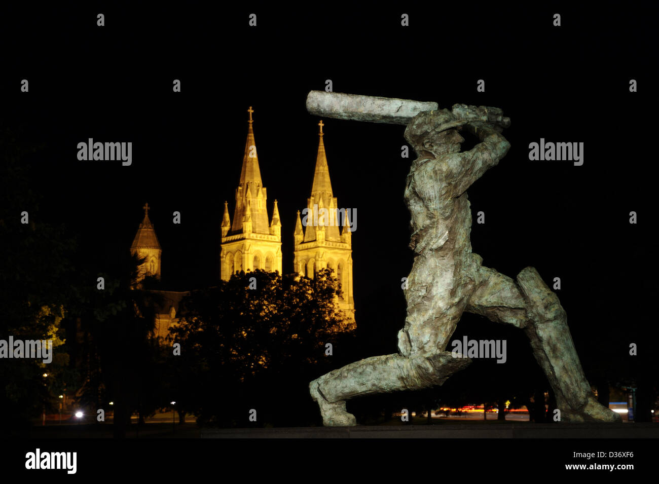 Statue de Sir Donald Bradman à Adelaide, Australie du Sud dans la nuit avec la cathédrale St Pierre à l'arrière-plan Banque D'Images