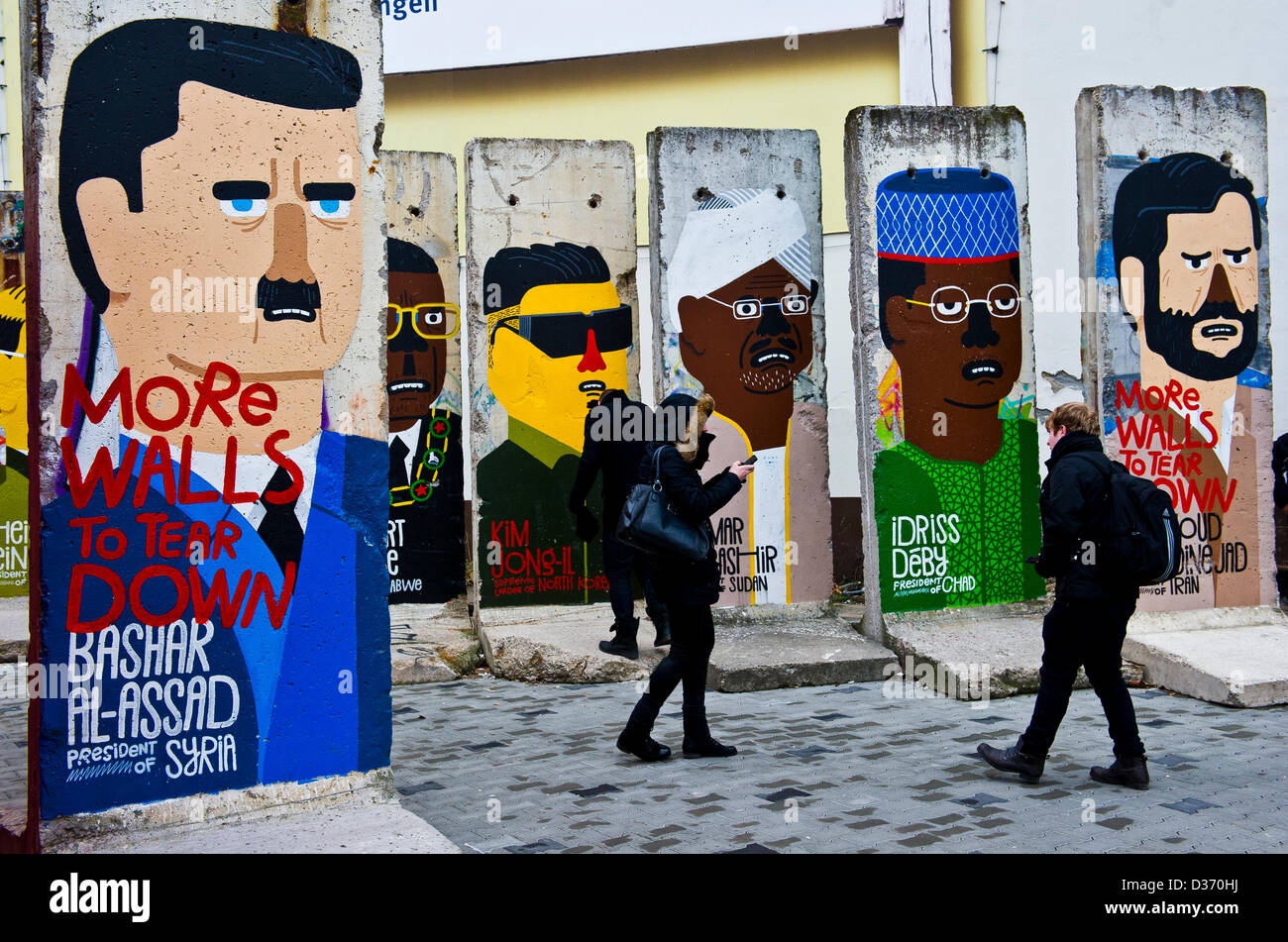 Berlin, Allemagne. 11 février 2013. Les touristes se tiennent près de morceaux de l'ancien mur de Berlin montrant le président de la Syrie Bachar El Assad (L-R), le Président du Zimbabwe Robert Mugabe, ancien dictateur nord-coréen Kim Jong-il, Président du Soudan Ular al-Baschir, Président du Tchad Idriss Deby et le président d'Iran Mahmoud Ahmadinejad avec l'écriture "oreWalls à abattre' à Berlin, Allemagne, 11 février 2013. Photo : Nicolas Armer/Alamy Live News Banque D'Images