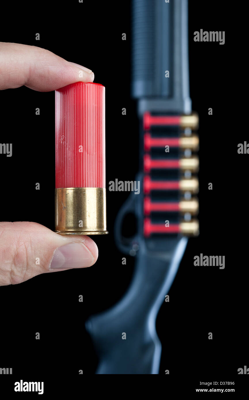 Un homme affiche un fusil à côté de shell un fusil à l'arrière-plan. Banque D'Images