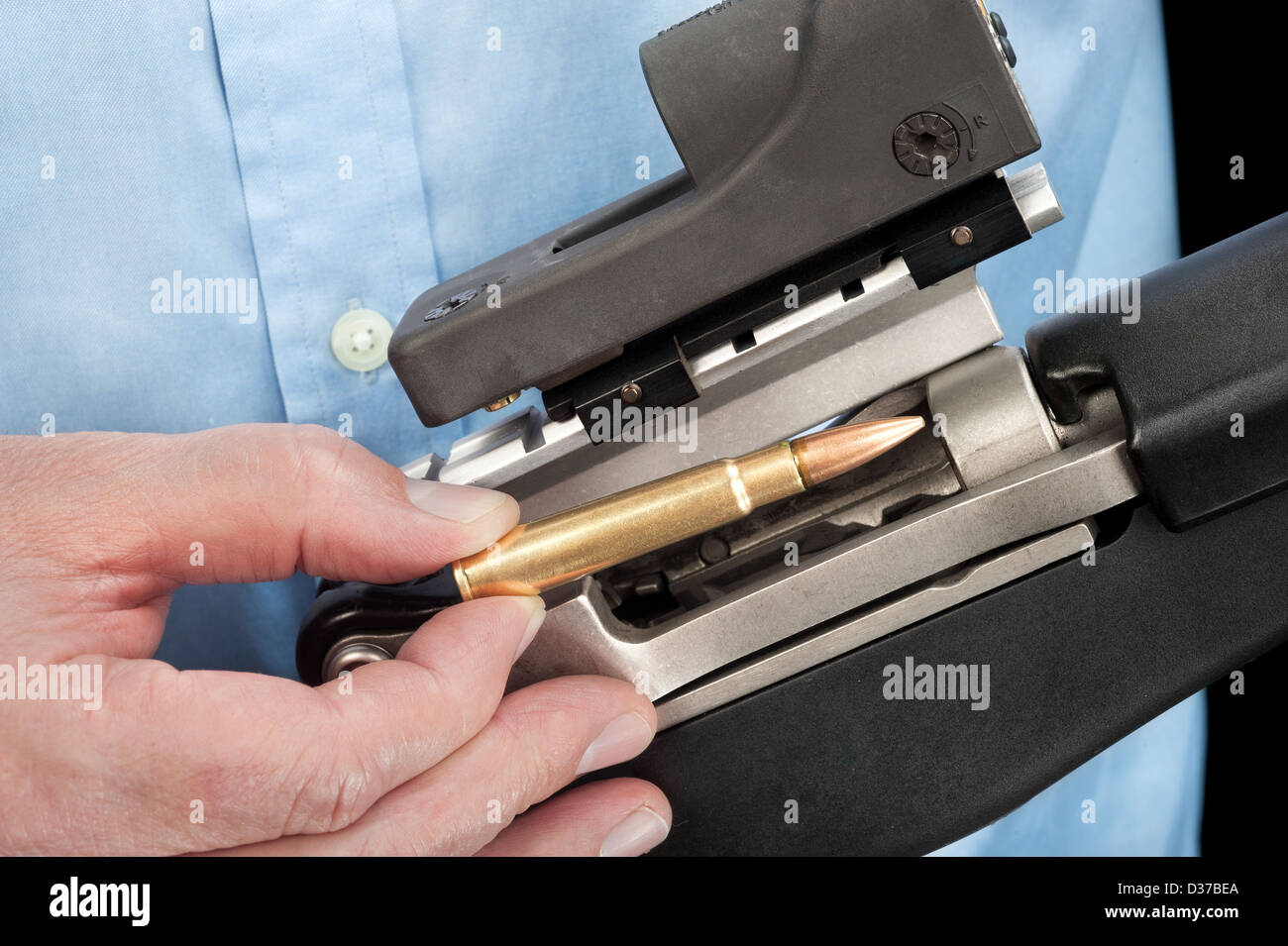 Un homme portant une chemise se charge un fusil d'assaut avec une seule balle 223 Banque D'Images