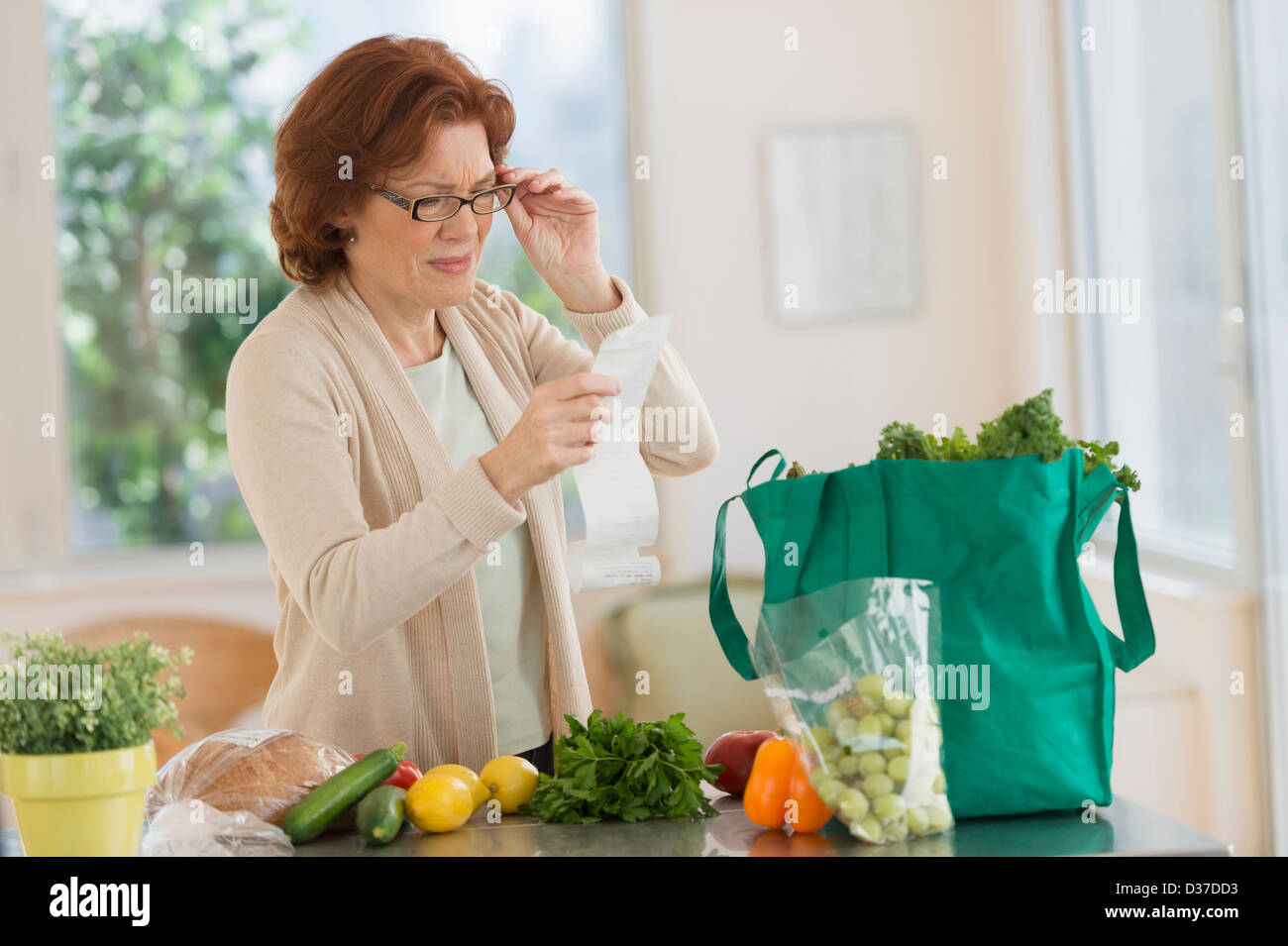 USA, New Jersey, Jersey City, Woman Reading Liste de courses dans la cuisine Banque D'Images