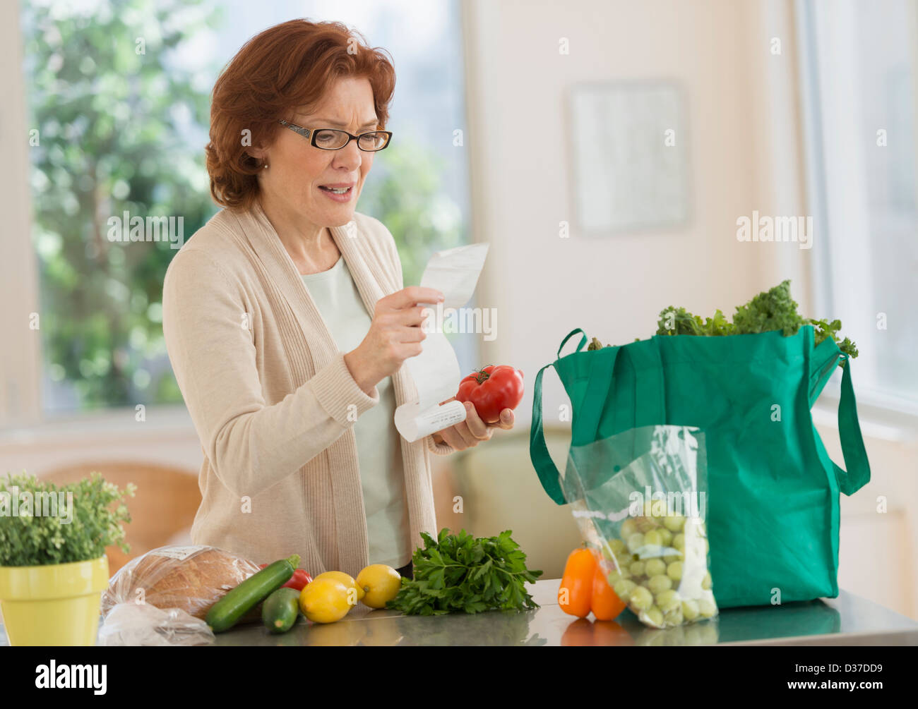 USA, New Jersey, Jersey City, Woman Reading Liste de courses dans la cuisine Banque D'Images