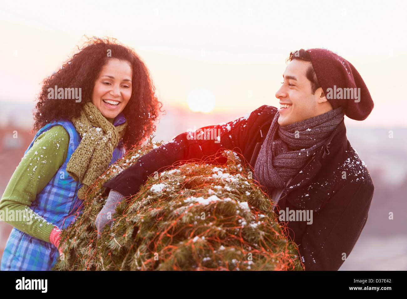 USA, New Jersey, Jersey City, Couple carrying Christmas Tree Banque D'Images