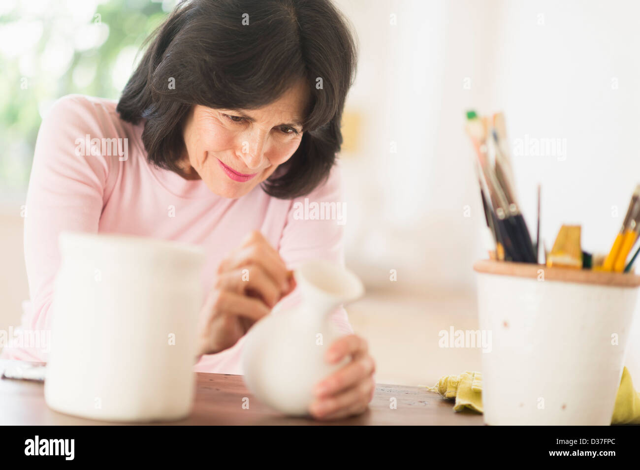 USA, New Jersey, Jersey City, Senior woman painting poterie fait main Banque D'Images