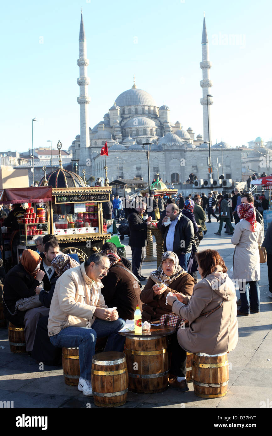 Les personnes mangeant à des stands de nourriture par le pont de Galata, avec Yeni Camii (mosquée) dans l'arrière-plan, Istanbul, Turquie. Banque D'Images