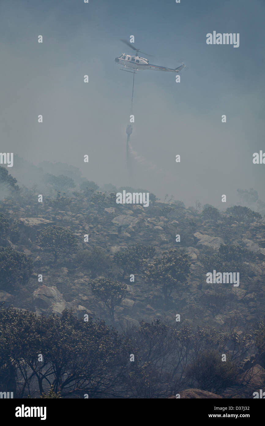 Un incendie à Hout Bay est éteint par un hélicoptère, il baisse le paysage eau admist smokey. Banque D'Images Un incendie à Hout Bay est éteint par un hélicoptère, il baisse le paysage eau admist smokey. Banque D'Images