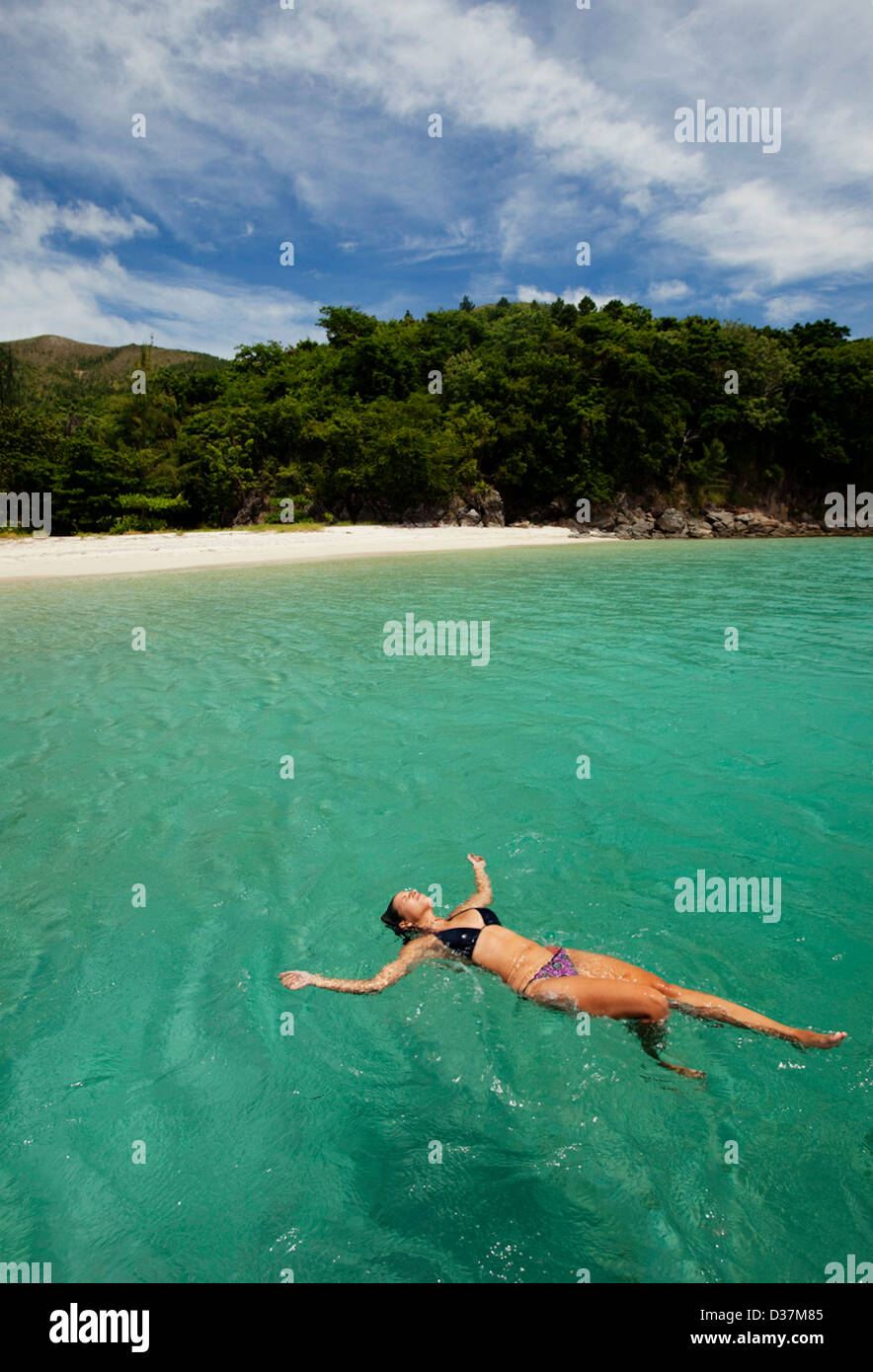 Woman floating in tropical eau Banque D'Images