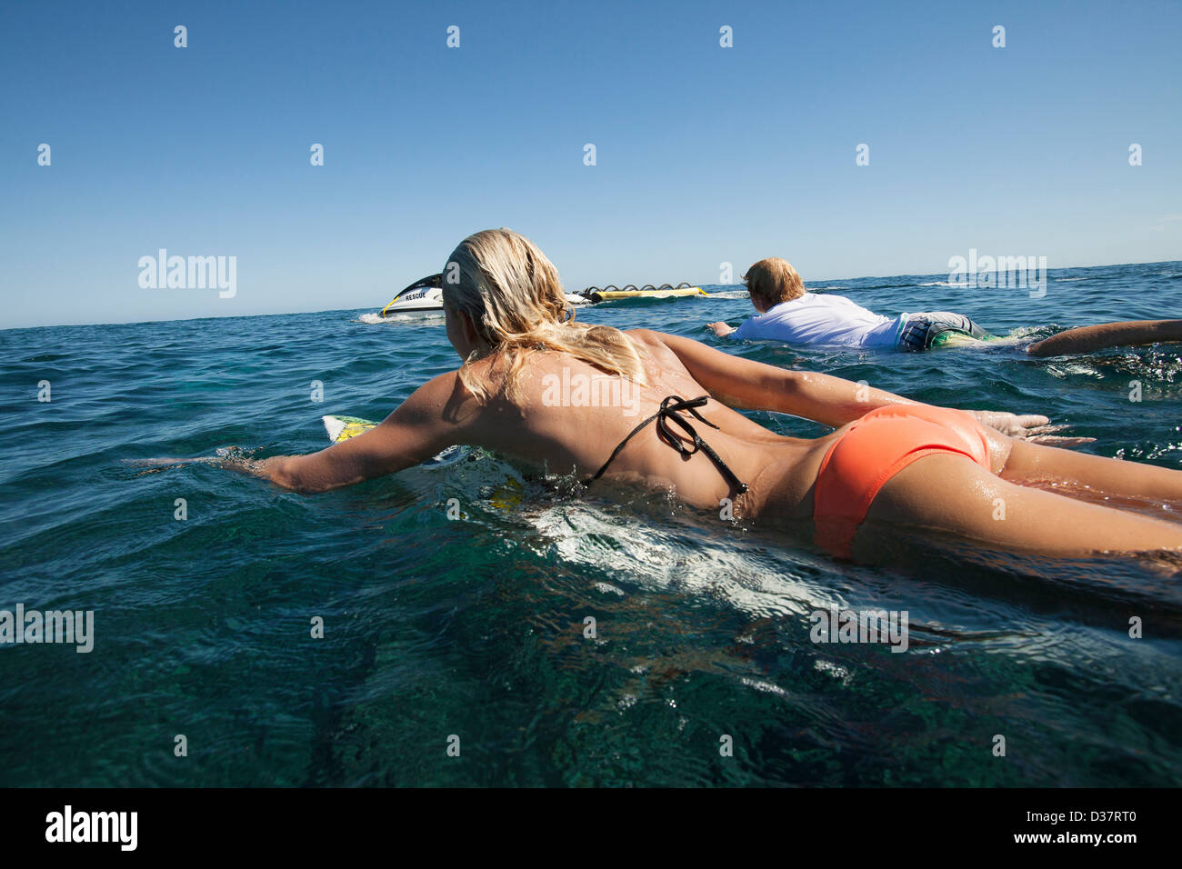 Surfers paddling en mer Banque D'Images