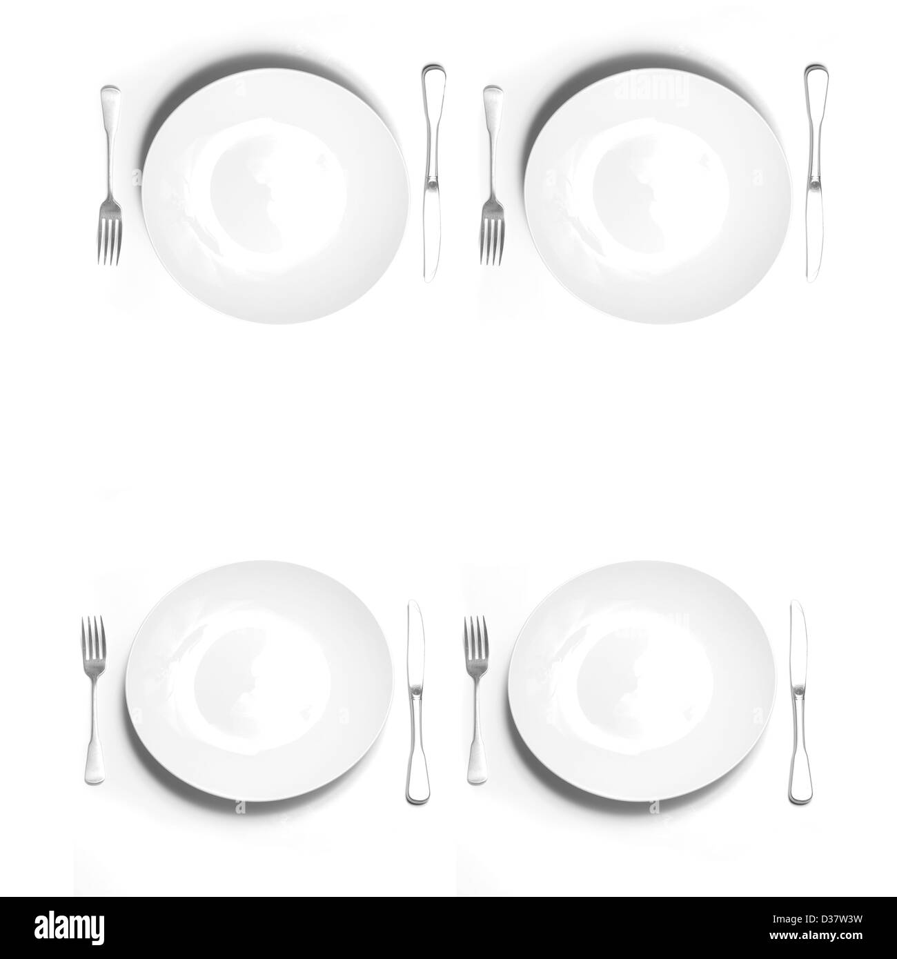 Couteaux et fourchettes de l'argenterie avec les plaques blanches sur fond blanc Banque D'Images