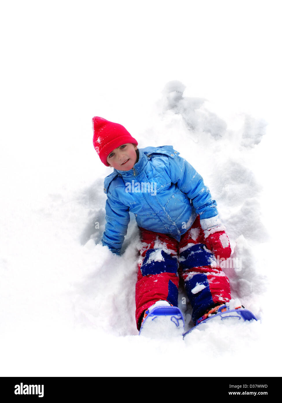 Enfant jouant dans l'hiver assis dans la neige Banque D'Images