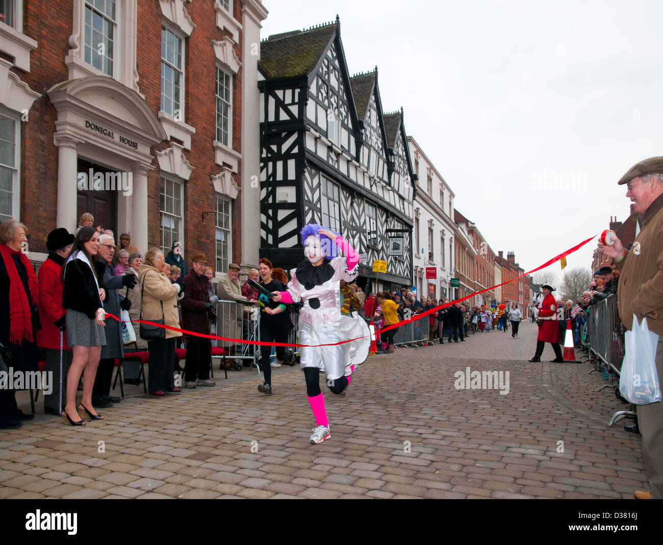 Andrea Mulchrome remportant la course de crêpes Womens qui fait partie de la Foire des Jours gras traditionnels dans l'alésage Street Lichfield Staffordshire, Angleterre Royaume-uni sur le Mardi Gras 12 février 2013. Ces courses ont eu lieu chaque année à Madrid depuis 1978. Banque D'Images