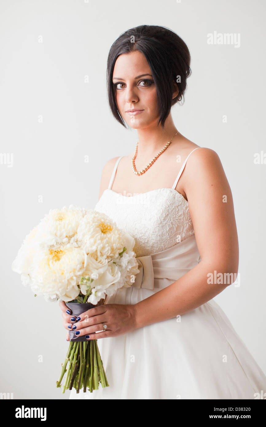 Studio Shot portrait of bride holding bouquet Banque D'Images