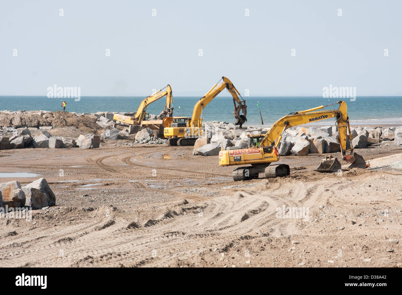 Excavateurs mécaniques engagés dans des travaux de construction de défense contre la mer Banque D'Images