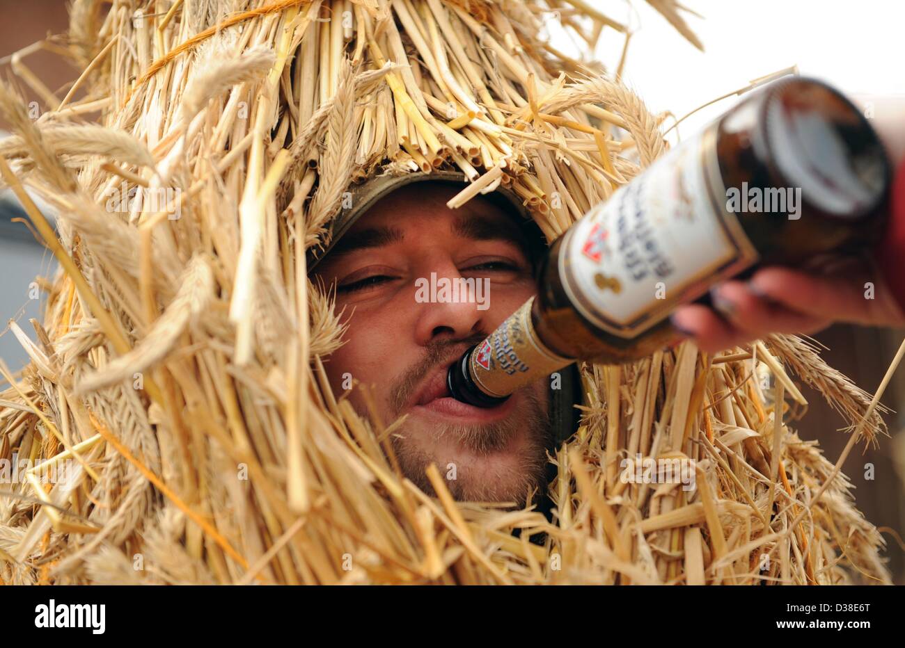 Heldra, Allemagne. 13 février 2013. Eike prend un zip de la bière pendant qu'il est habillé en ours en paille Heldra, Allemagne, 13 février 2013. Le mercredi des Cendres, les gens du village s'habiller comme les ours de paille pour chasser l'hiver. Photo : UWE ZUCCHI/dpa/Alamy Live News Banque D'Images