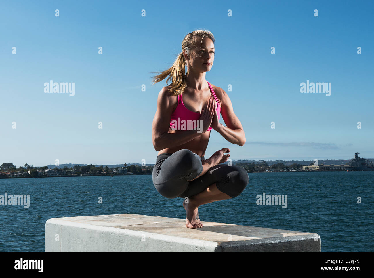 Woman practicing yoga on bloc de béton Banque D'Images