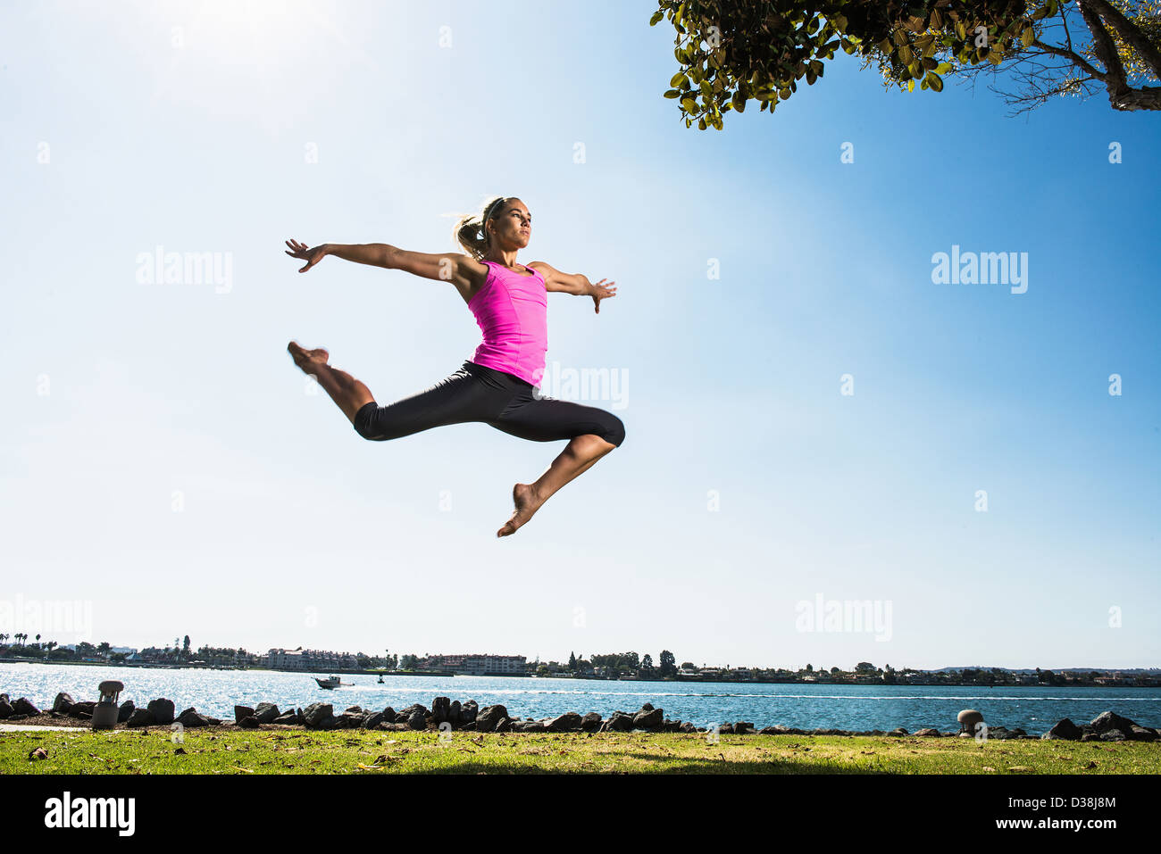 Femme sautant dans park Banque D'Images