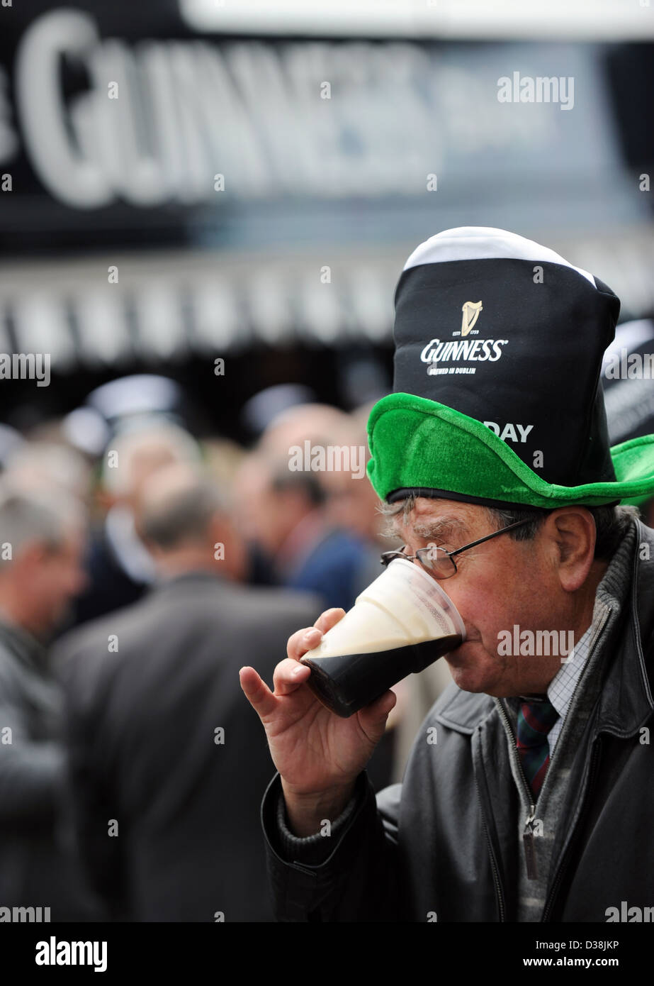 Un homme boit une pinte de Guinness sur Saint Patricks Day au cours de la Cheltenham Festival Banque D'Images