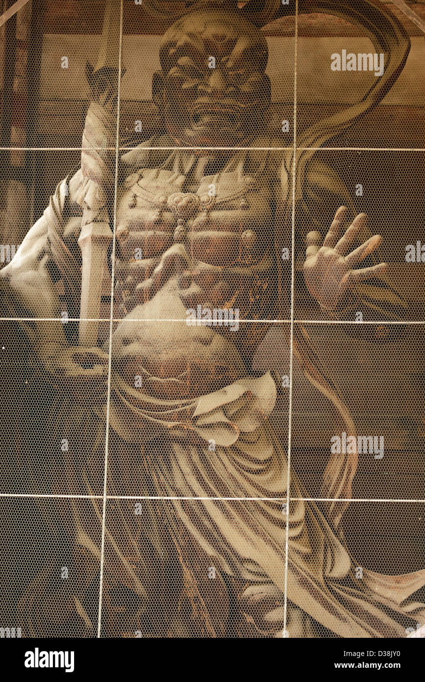 Démon géant statue en bois près de l'entrée de Temple Todai-ji, protégée par un écran de pigeon. Banque D'Images