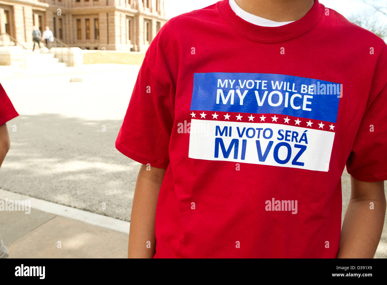 Jeune homme porte des t-shirt avec un message bilingue espagnol anglais disant que mon vote sera ma voix mi voto será mon voz Banque D'Images