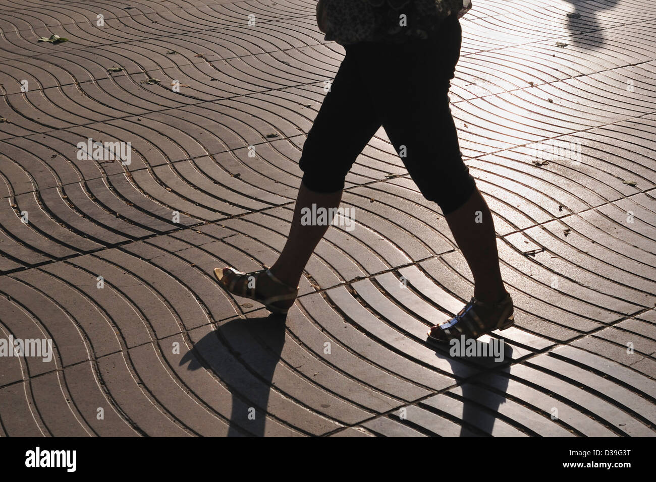 Sol carrelé de l'onde de la chaussée de la rue célèbre Rambla à Barcelone avec une silhouette de femme de marche Banque D'Images