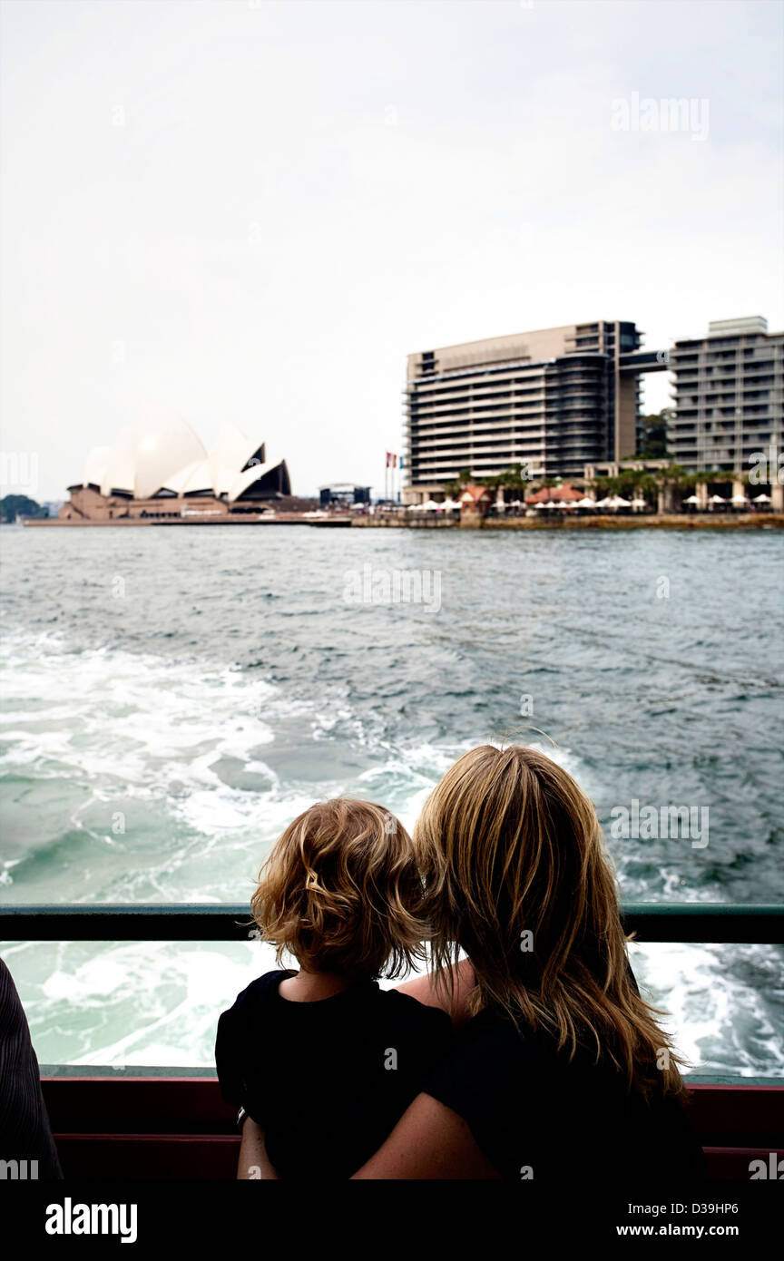 Une mère et son fils, ni de l'arrière d'un Ferry de Sydney à l'Opéra de Sydney et le Sydney skyline. Banque D'Images