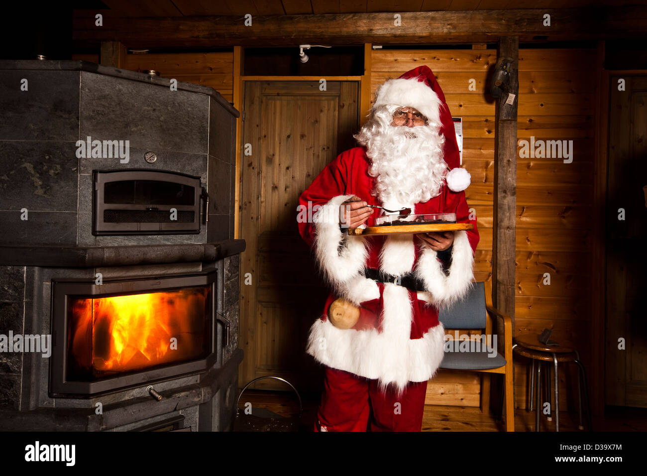 L'homme en costume de Père Noël de manger des aliments, Laponie Banque D'Images