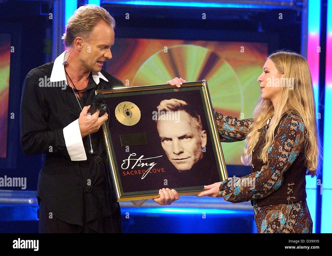 (Afp) - Popstar Sting reçoit l'or pour son album "sacré record Love' de son plus grand fan, Janine Bub, au cours de l'émission de télévision ARD 'Gold, Gold, Gold' à Hambourg, le 7 novembre 2003. Fans à l'âge entre 7 et 70 pourrait s'appliquer par vidéo pour satisfaire leur idole et de remettre les prix. Banque D'Images