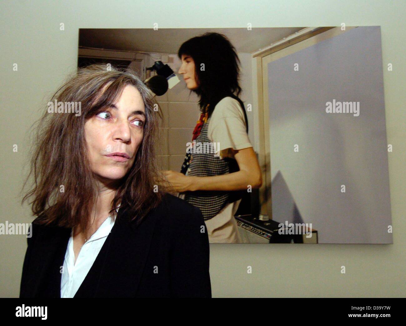 (Dpa) - US rock star Patti Smith se tient juste en face de la peinture 'Patti Smith III" par l'artiste suisse Franz Gertsch lors d'une visite du musée Pinakothek der Moderne à Munich, le 18 décembre 2003. La peinture photoréaliste date de 1978 et montre Patti Smith au travail dans le studio. Banque D'Images