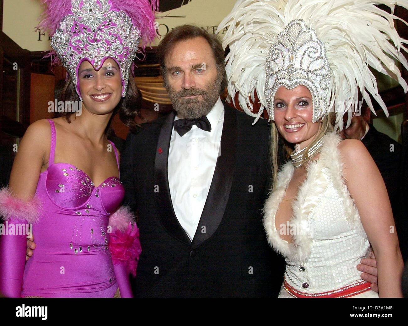 (Afp) - L'acteur italien Franco Nero est accompagné dans la salle de bal par deux hôtesses au 20e Bal de l'Opéra de Francfort, 23 février 2002. Néron était un des invités internationaux. Banque D'Images