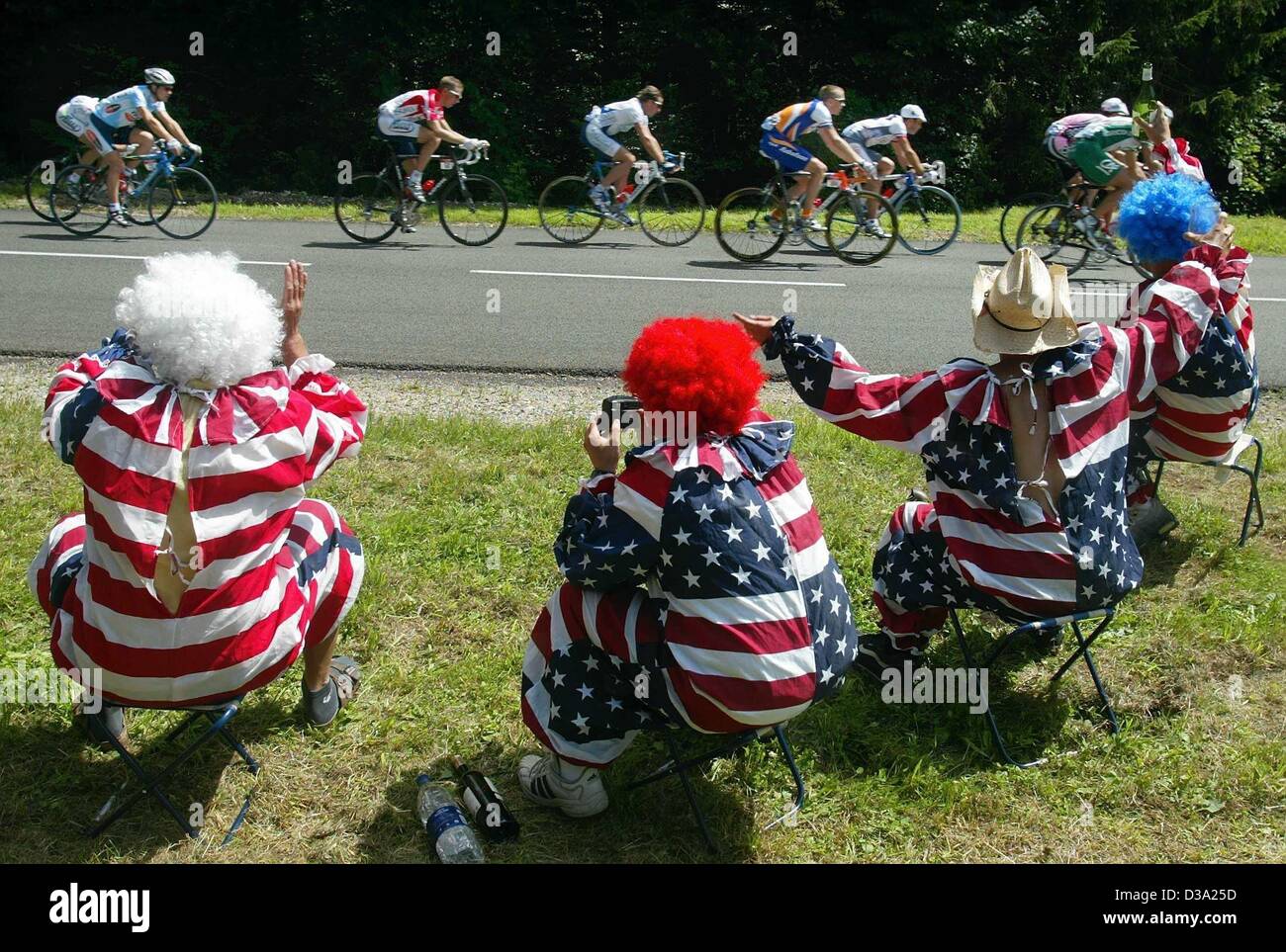 (Afp) - Quatre supporters de l'équipe cycliste US, portant les costumes des Stars and Stripes flag cheer, aux côtés de la 18e étape du Tour de France de Cluses à Bourg-en-Bresse, à Bourg-en-Bresse, le 26 juillet 2002. Banque D'Images