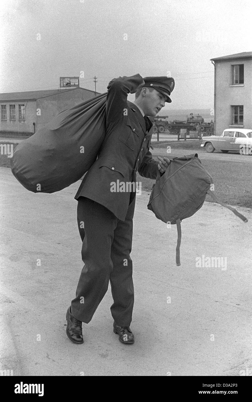 (Afp) - Elvis Presley est transporter des sacs à l'extérieur de la Ray Barracks près de Friedberg, Allemagne, 2 octobre 1958. L'American rock 'n' roll star j'ai fait une partie de son service militaire dans la région de Hesse à la fin des années 50. Banque D'Images