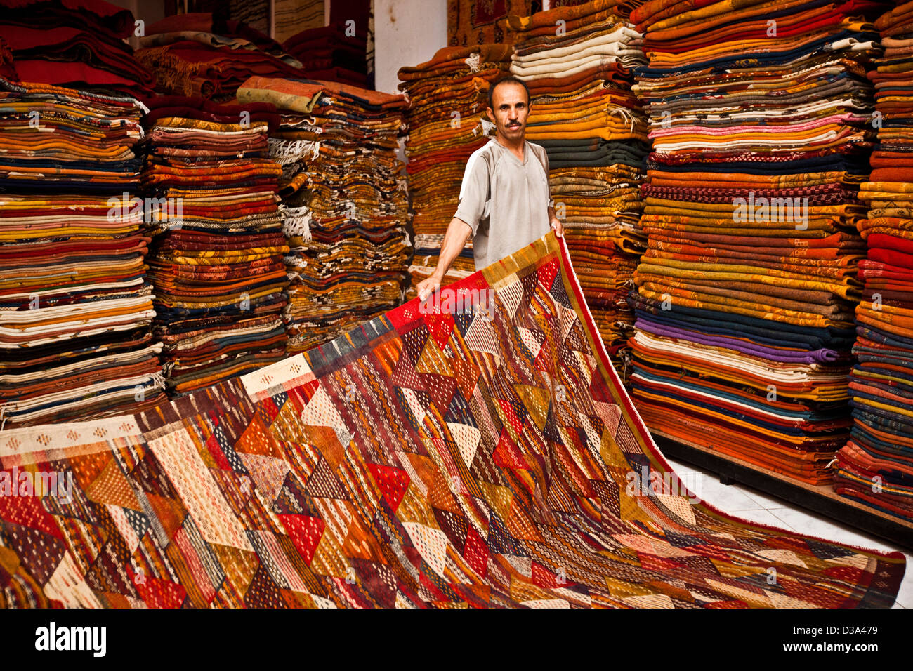 Marchand de tapis holding à vendre au souk, Marrakech, Maroc Banque D'Images