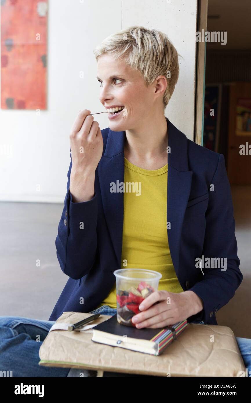 Smiling woman eating salad Banque D'Images