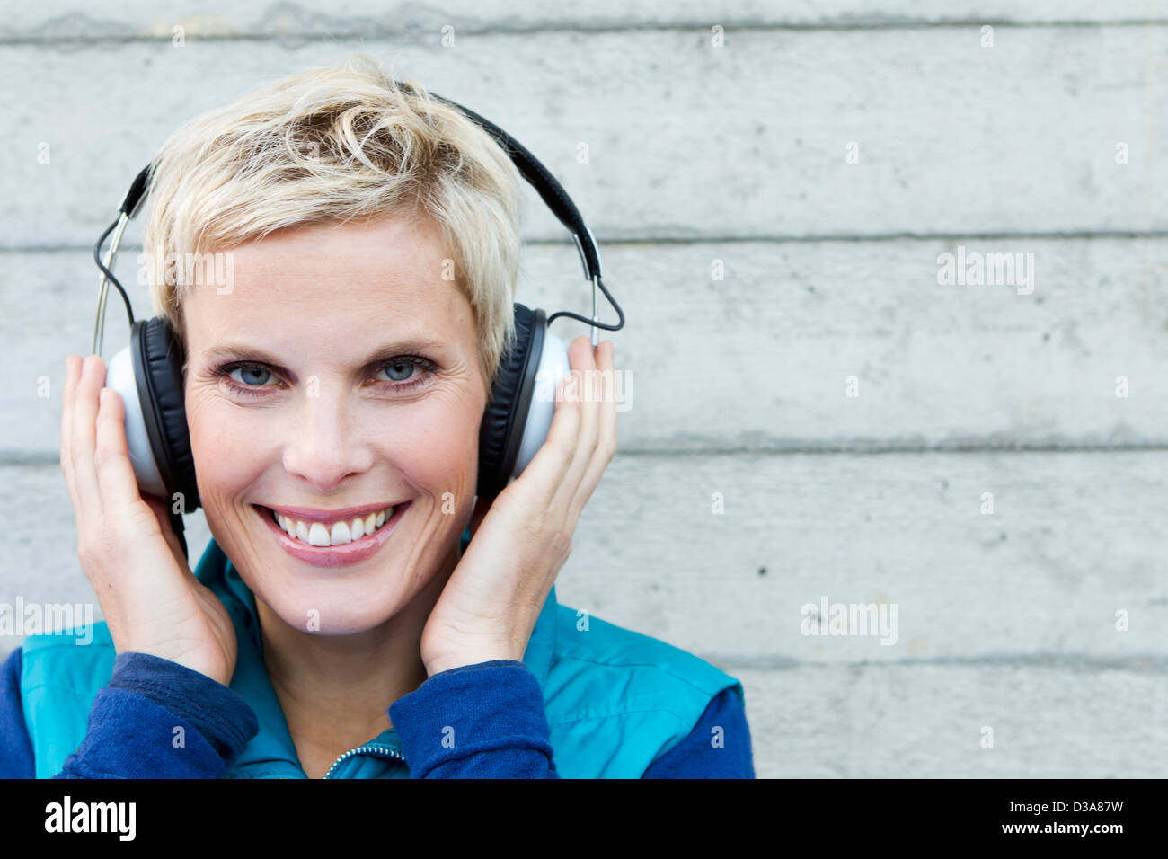 Smiling woman listening to headphones Banque D'Images