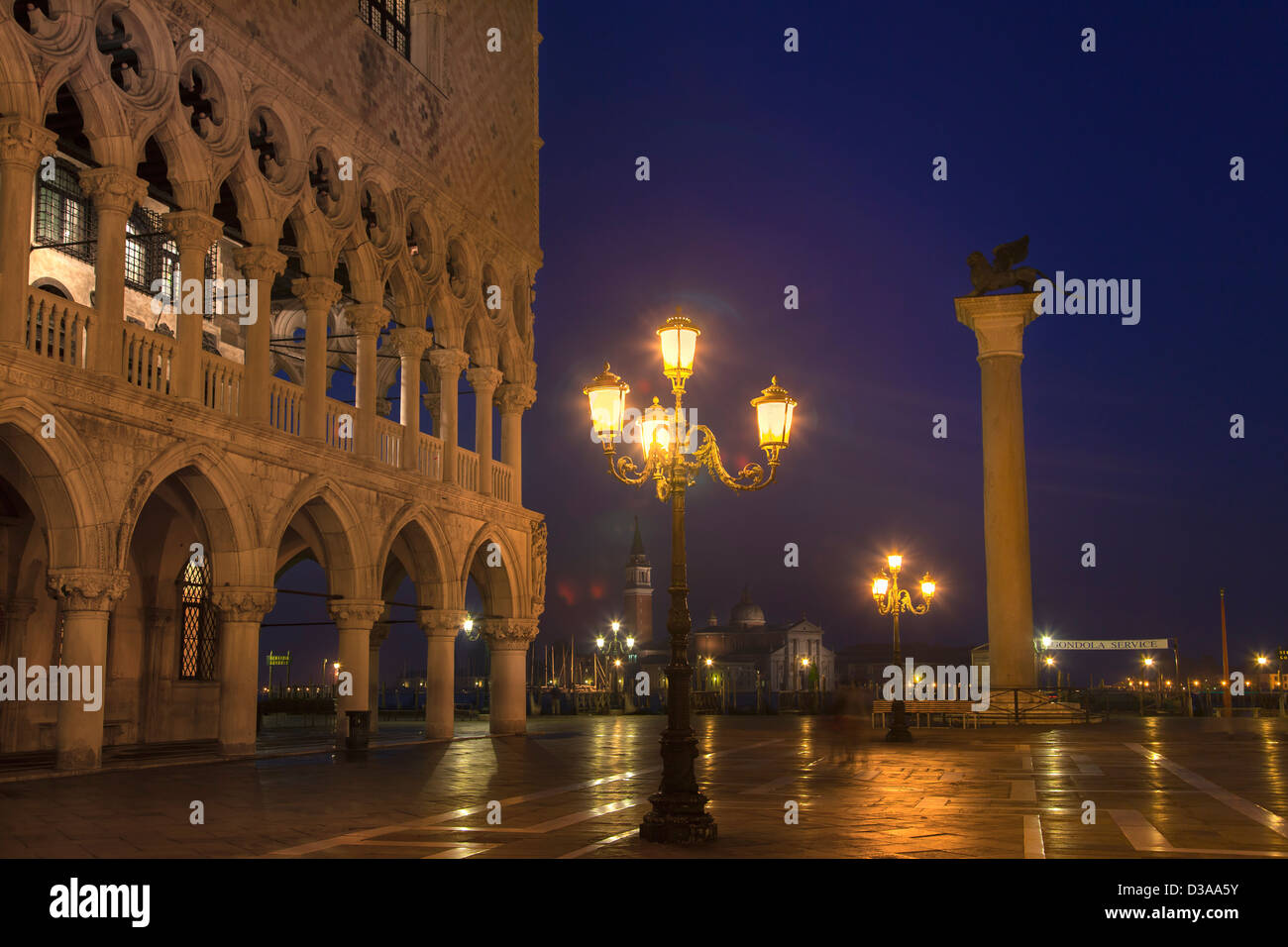 Les lumières de la ville reflétée sur la rue humide Banque D'Images