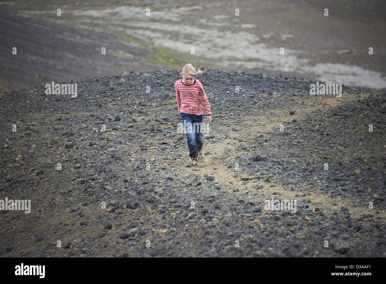 Fille qui marche dans un paysage rocheux Banque D'Images