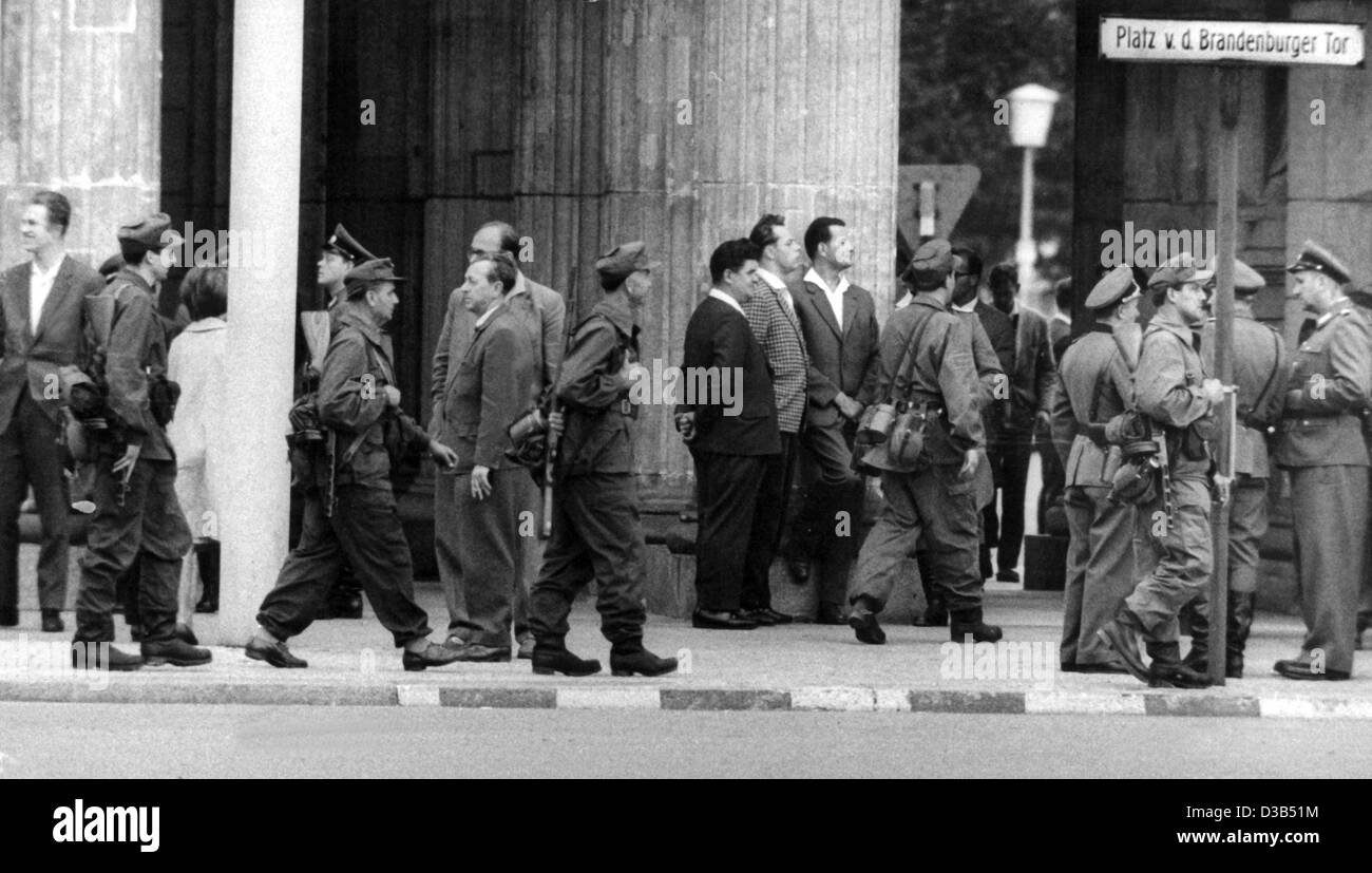 (Afp) - Les agents de la police du peuple est-allemand (Volkspolizei) et les milices de travailleurs posté le long de la ligne de démarcation du secteur soviétique se tenir en face de la porte de Brandebourg à Berlin, le 13 août 1961. Au début de ce dimanche matin, des fils barbelés et des barbelés ont été placés sur l'acce Banque D'Images