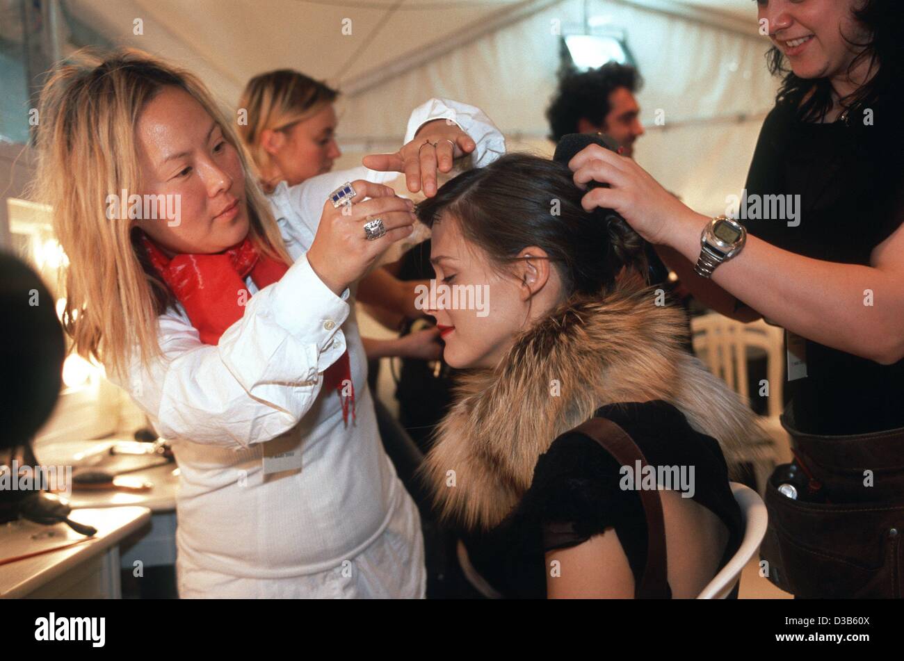 (Afp) - deux coiffeurs sont fixant la coupe de cheveux de top model Carmen Kass pour les Louis Vuitton fashion show à Paris, le 11 mars 2002. Kass est né à Tallinn, en Estonie, en 1978. Elle a été contactée par un modèle scout dans un supermarché. Elle a reçu de l'année 'modèle' à la VH-1/Vogue fashion UN Banque D'Images