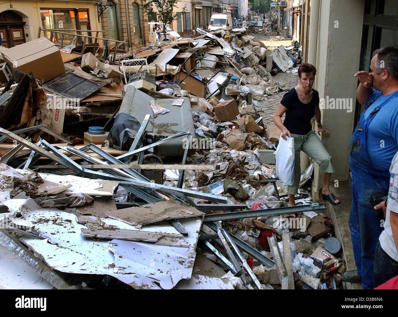 (Afp) - Une femme fait son chemin à travers les ordures des maisons inondées s'empilent sur la rue à Pirna, 21 août 2002. Après l'eau élevée retirées et laissé un chaos, les résidents sont occupés à nettoyer. Les pires inondations en Allemagne dans un siècle a causé des dommages catastrophiques estimées dans les bil Banque D'Images