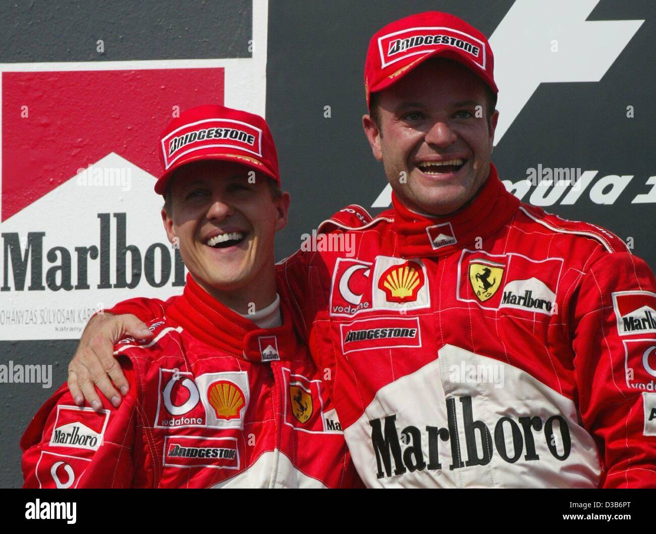 (Afp) - pilote de Formule 1 brésilien Rubens Barrichello (R) et son coéquipier de Ferrari, l'Allemand Michael Schumacher, cheer sur leur double victoire après le Grand Prix de Hongrie sur le Hungaroring, près de Budapest, Hongrie, 18 août 2002. Barrichello a remporté la première place et Schumacher est arrivé en deuxième position. Banque D'Images