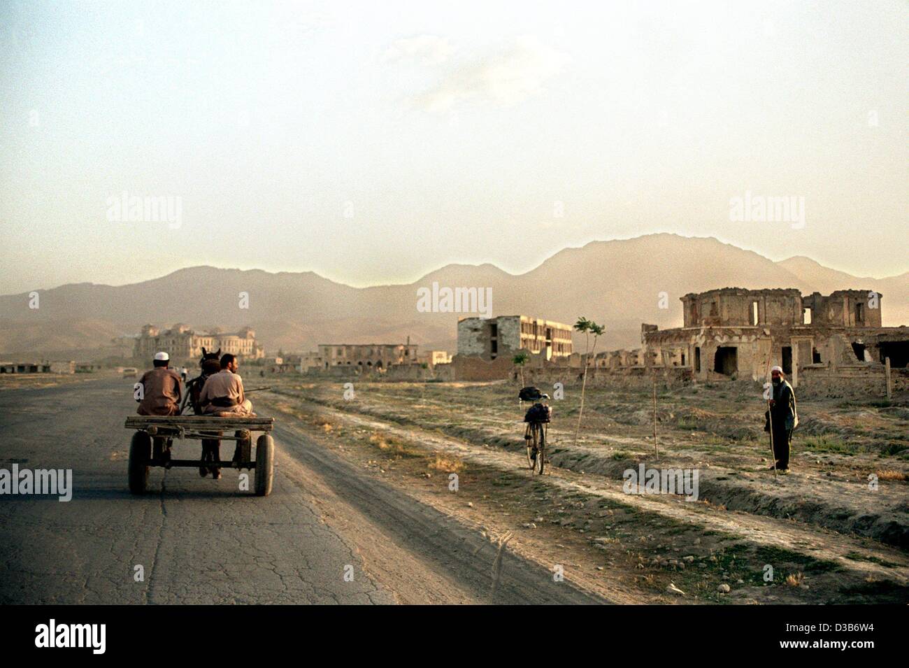 (Afp) - Deux hommes sur un cheval en calèche à travers une zone désolée dans le sud de la capitale afghane KABOUL, juin 2002. Après la destruction de l'infrastructure rurale pendant la guerre, l'Afghanistan traverse une crise financière et a un besoin urgent de soutien international pour lancer reconstructi Banque D'Images