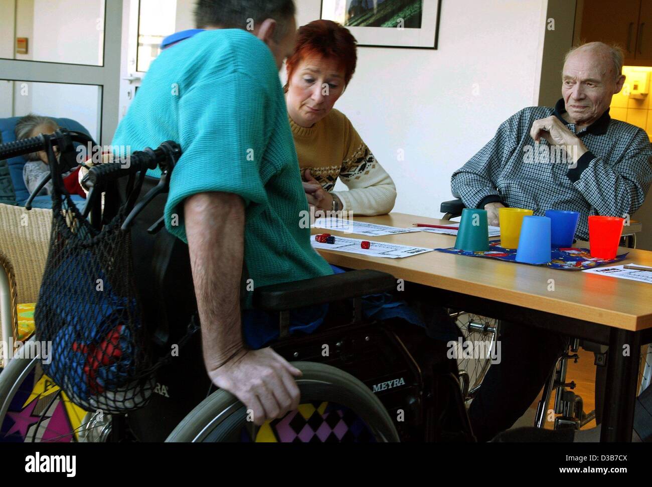 (Afp) - Accompagnateur Maria Reinhold (C) participe à un jeu de dés avec les personnes âgées ayant besoin de soins dans un foyer de soins de courte durée à Bottrop, Allemagne, 10 décembre 2002. Soins de courte durée est offert par le club 'Soziale Dienste" (l'aide sociale) dans un quartier d'habitation pour les personnes âgées. Soins de courte durée est un important Banque D'Images